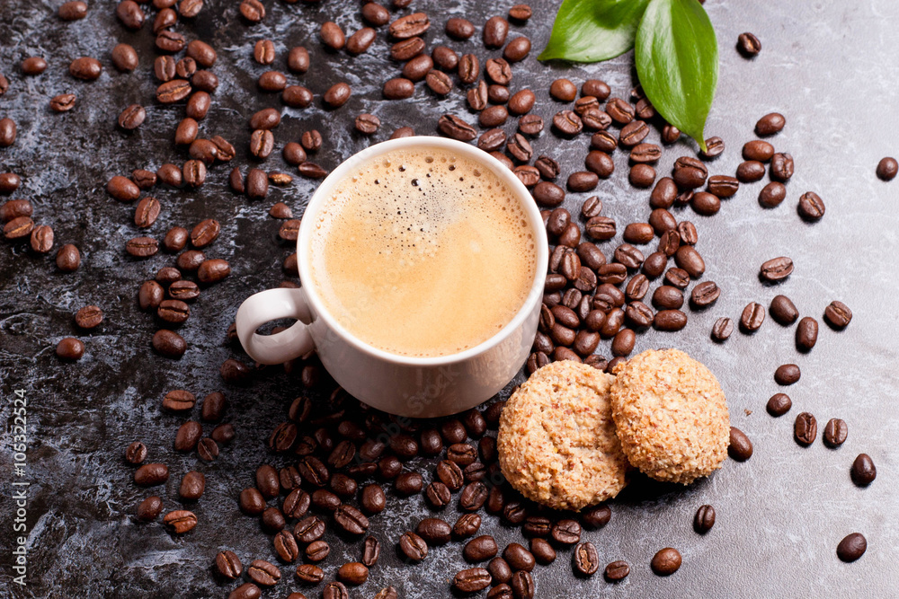 cup of fresh americano and cookies on coffee beans background
