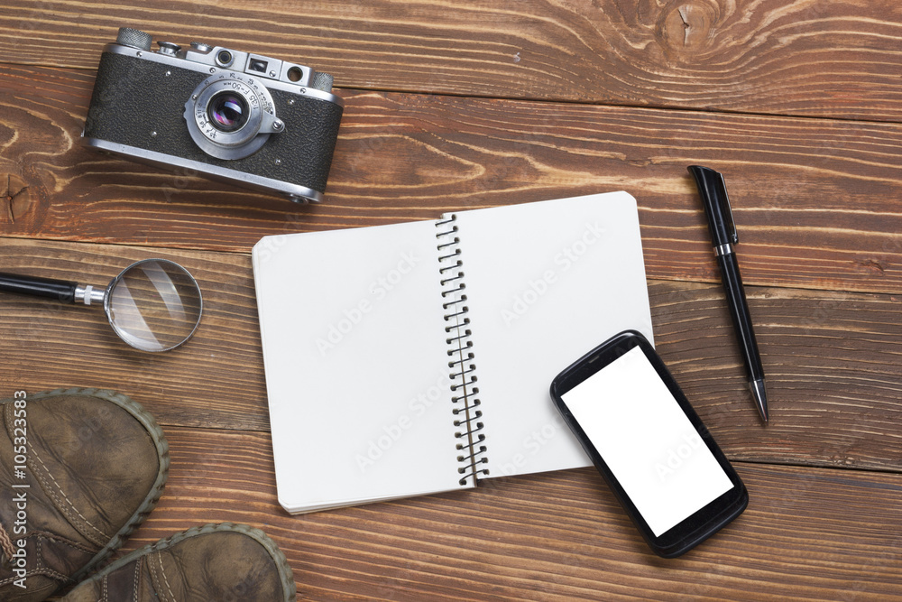 Travel, vacation concept. Camera and supplies on office wooden desk table. Top view with copy space for text Travel, vacation concept. Camera and supplies on office wooden desk table. Top view with copy space for text