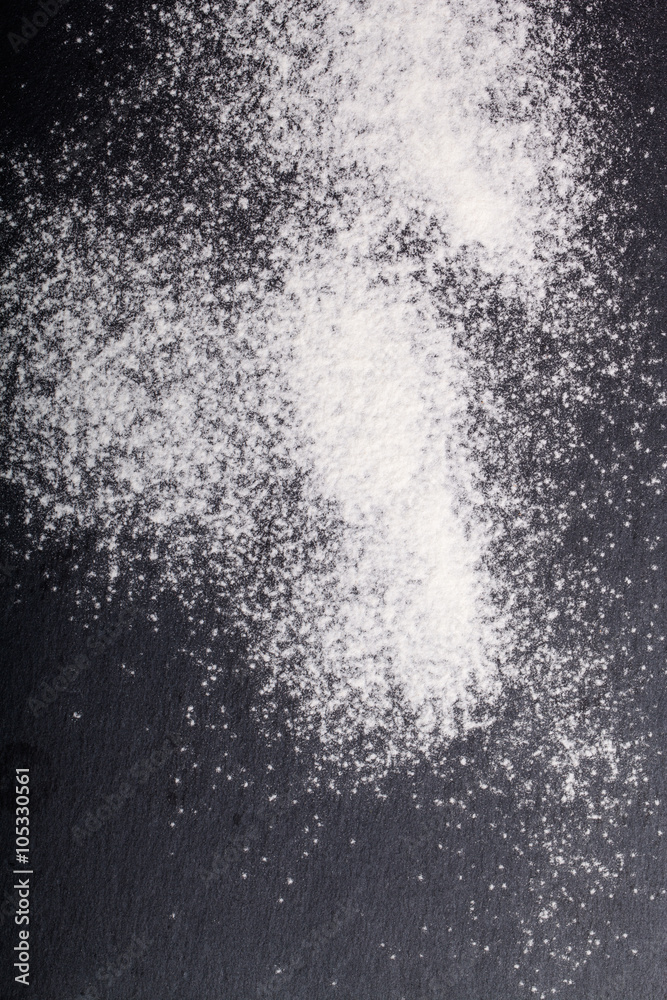 Obraz premium Flour spilling on color background of slate cutting board