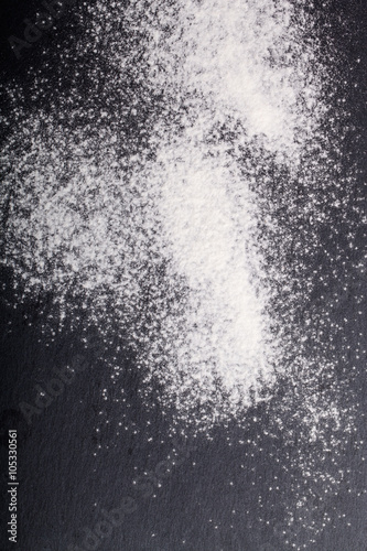 Flour spilling on color background of slate cutting board
