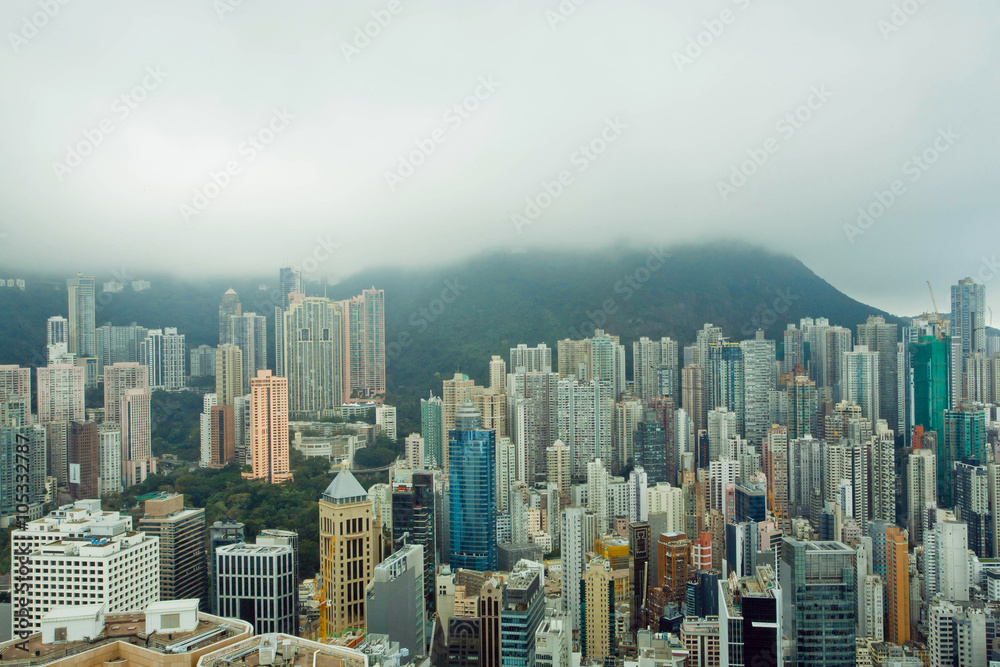 Skyscrapers on green hills before rain in Hong Kong