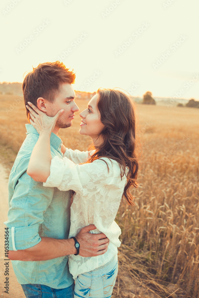 Young couple in love outdoor.Stunning sensual outdoor portrait of young stylish fashion couple posing in summer in field Young couple in love outdoor.Stunning sensual outdoor portrait of young stylish fashion couple posing in summer in field