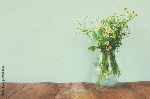 Fototapeta Naklejka Na Ścianę i Meble -  fresh daisy flowers on wooden table. vintage filtered
