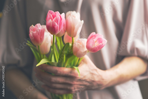 Fototapeta Naklejka Na Ścianę i Meble -  Bouquet of pink tulips in female hands