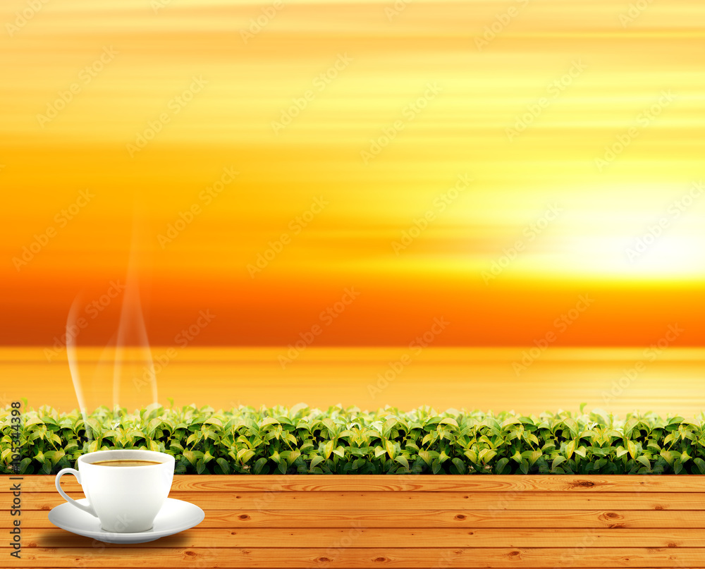 coffee cup on wood floor in outdoor park and orange sky sunlight and sea background