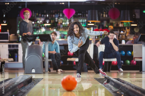 Leinwand Poster young black woman plays bowling