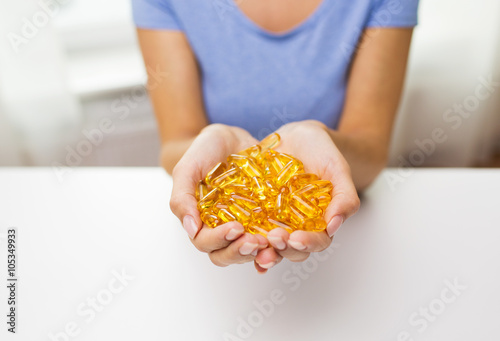 close up of woman hands holding pills or capsules