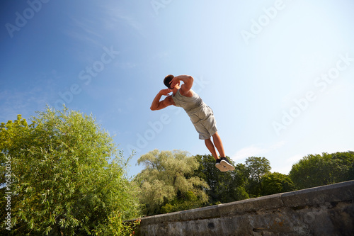 sporty young man jumping in summer park