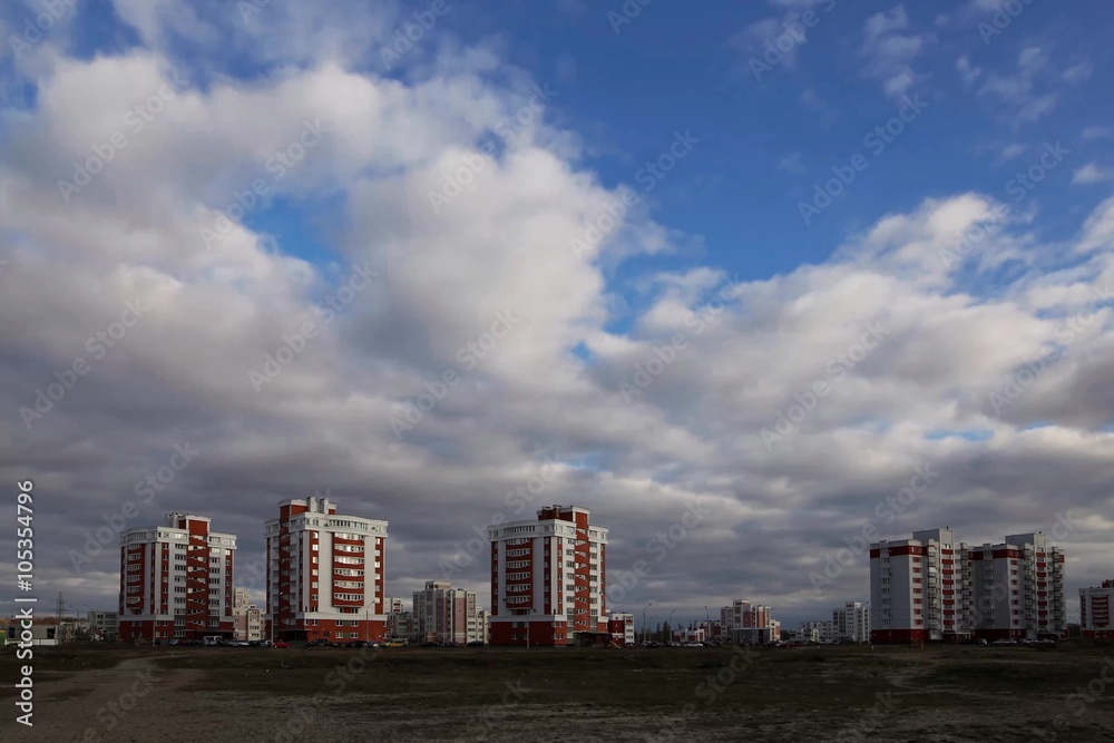 A dark cloudy sky over a city with tall buildings. A dark cloudy sky over a city with tall buildings.
