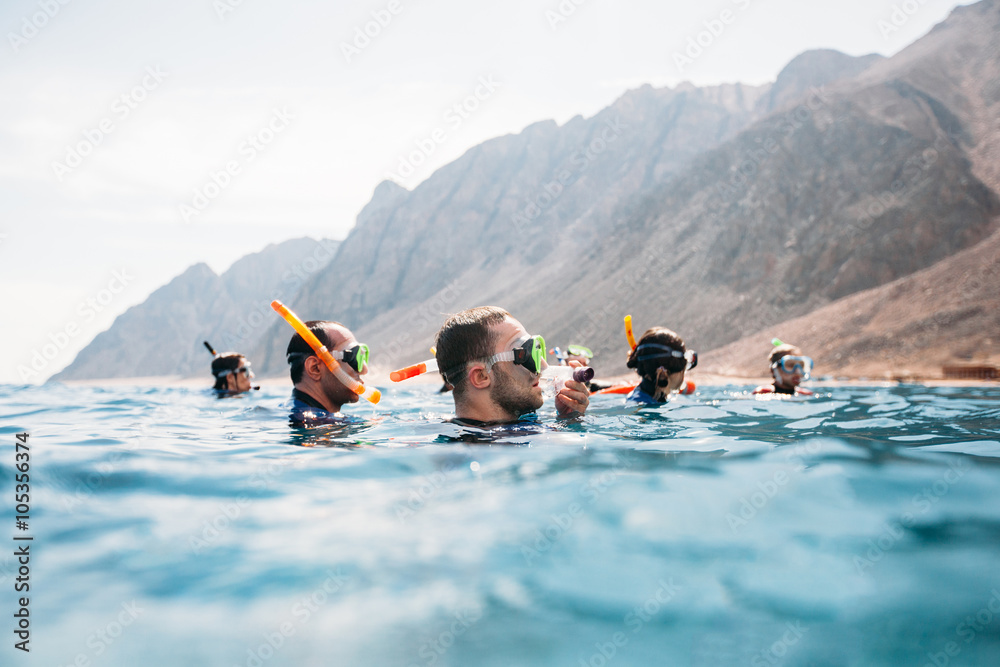 Group of friends snorkeling in a sea - obrazy, fototapety, plakaty 