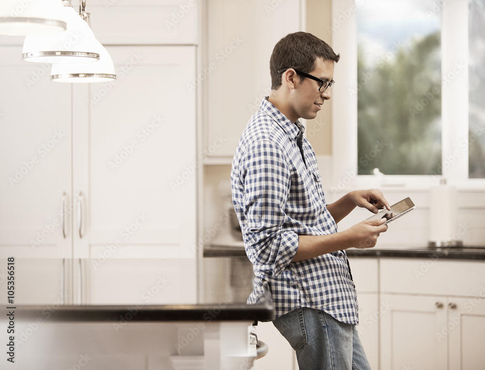 A man sitting at home using a digital tablet, A man sitting at home using a digital tablet,