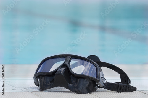 Swimming diving mask at the edge of a swimming pool.