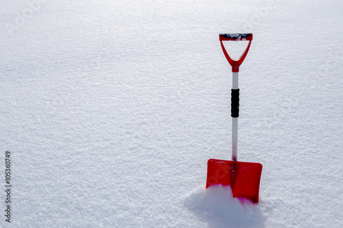 Red snow shovel standing in the snow photo