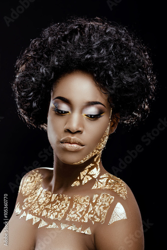 Young african woman posing on the black background