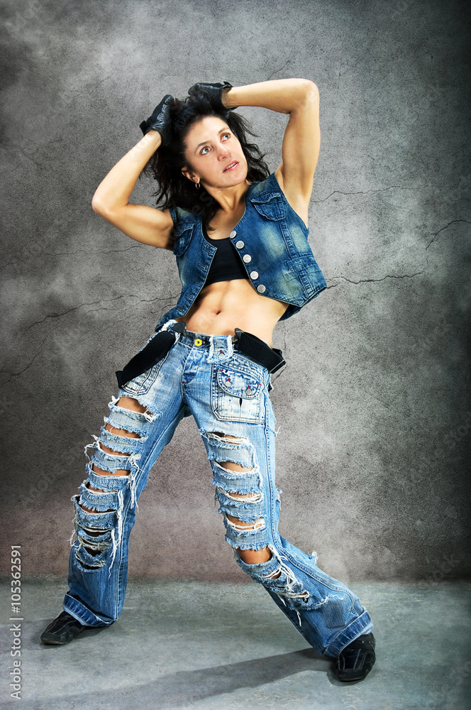 Young beautiful athletic woman in fashion jeans dancing modern style