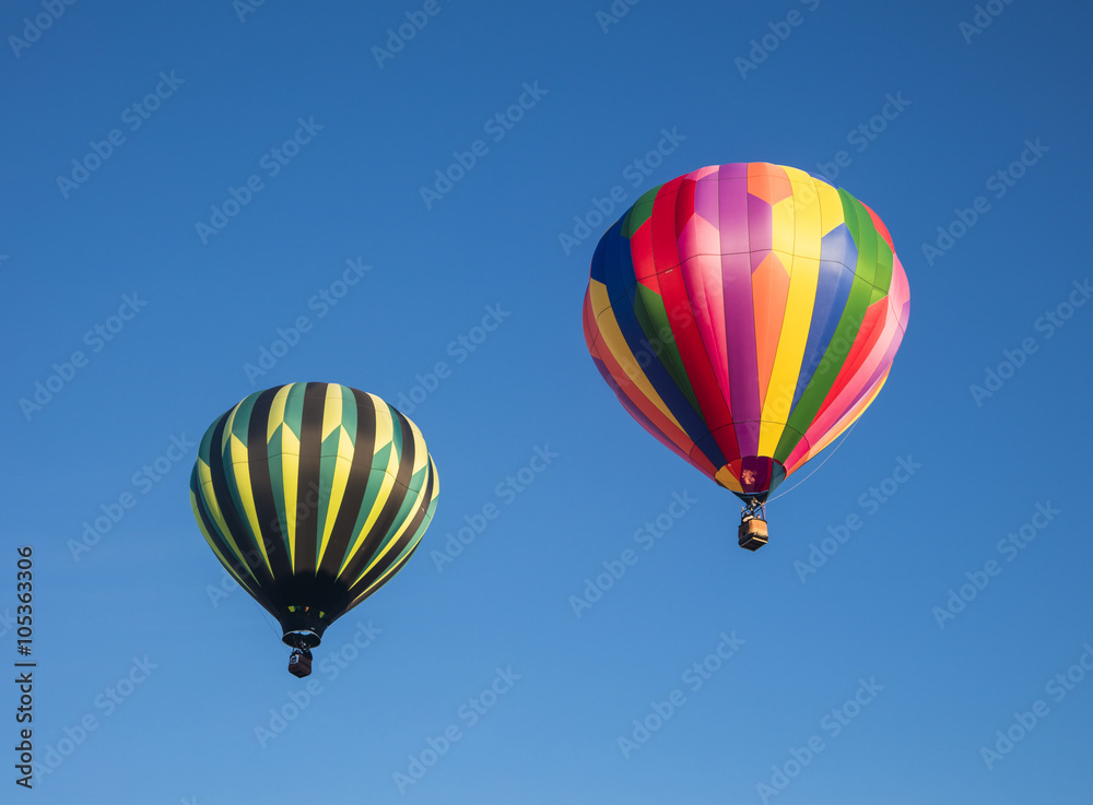 Two hot air balloons against a deep blue sky Two hot air balloons against a deep blue sky
