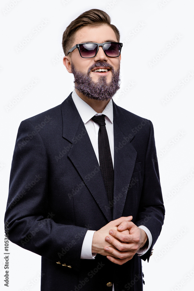 Cheerful businessman posing with hand near his beard