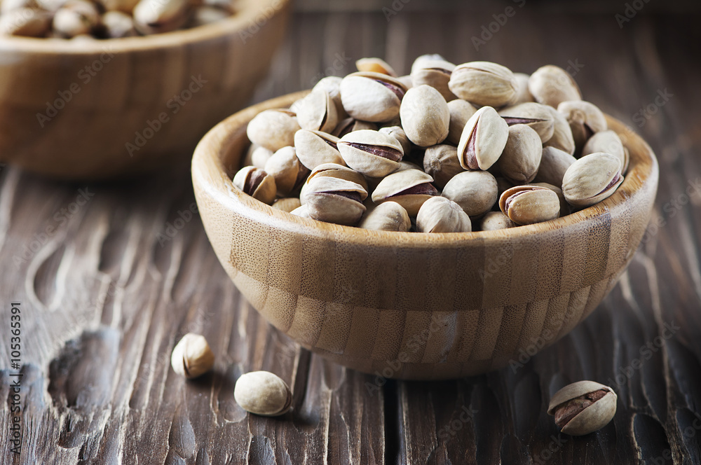 Salt pistachio nuts in the wooden bowl Salt pistachio nuts in the wooden bowl
