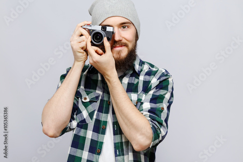 Smiling hipster holding camera in front of his face