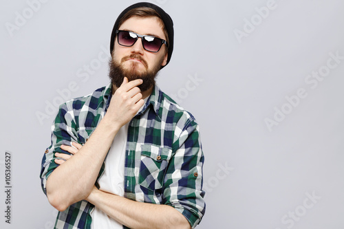 Young brutal man thinking on white background, in studio