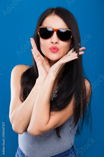 Beautiful young girl posing on the blue background