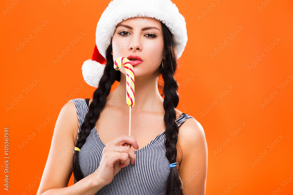 Fototapeta premium Sexy young woman posing with colorful candy near her lips