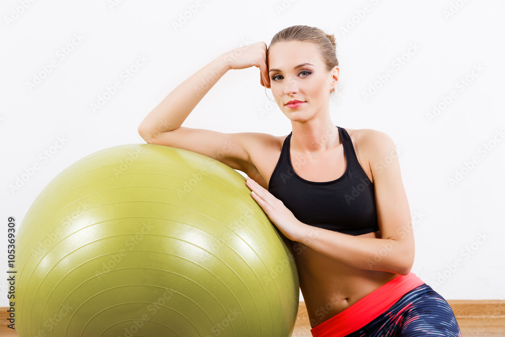 Attractive girl sitting with fitball at gym Attractive girl sitting with fitball at gym