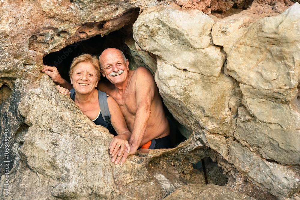 Senior happy couple having fun at the entrance of Kayangan Cave in Coron - Adventure travel in Philippines and asian destinations - Concept of active elderly around the world with no age limitation