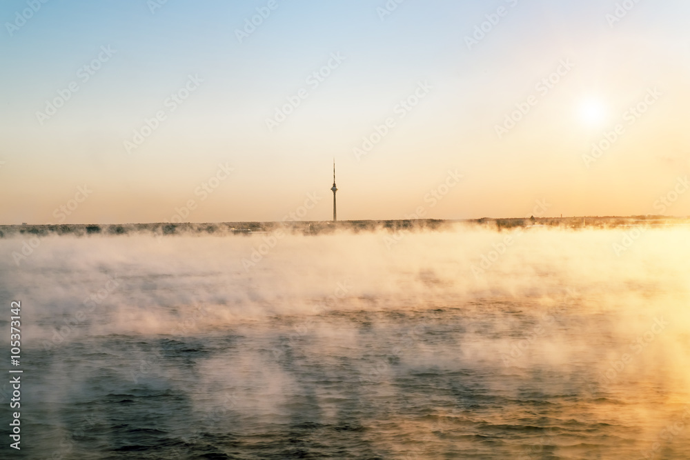 View from the sea to the TV tower in Tallinn at dawn in the fog.