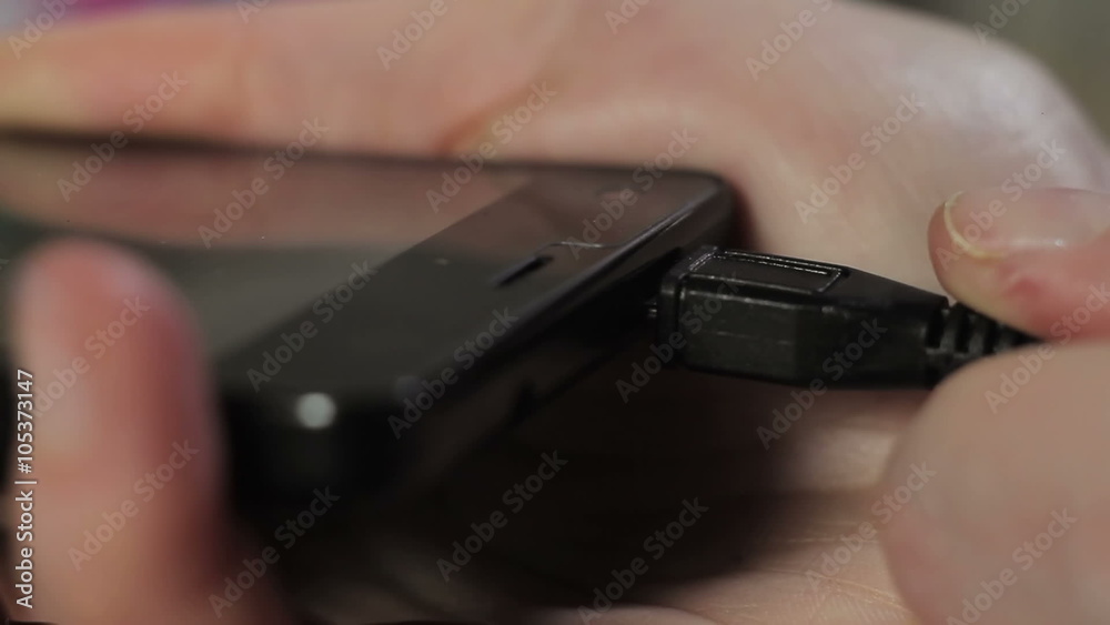 Smartphone charging with USB charger close-up of hands Smartphone charging with USB charger close-up of hands