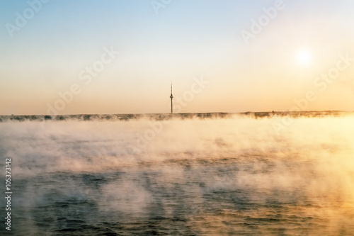 View from the sea to the TV tower in Tallinn at dawn in the fog.