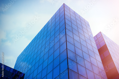 Perspective and underside angle view to textured background of modern glass blue building skyscrapers. Sunset light, Blue sky, horizontal mockup. 3d render