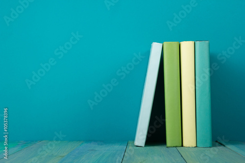 Row of colorful books, grungy blue background, free copy space