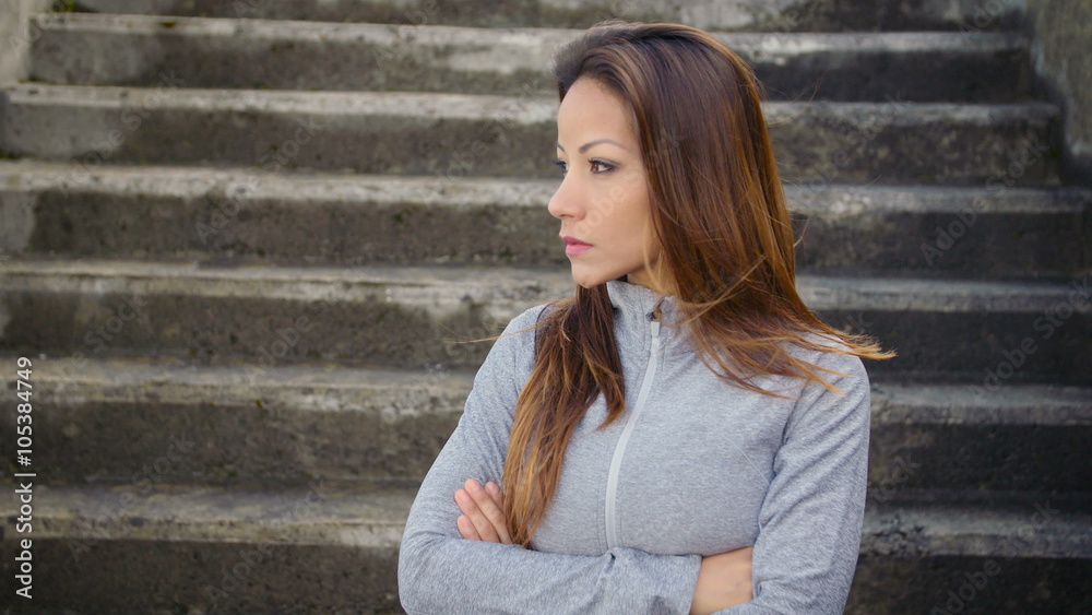 Fitness woman standing with arms crossed and looking challenging. Serious latin motivated athlete portrait. Motivation and sporty lifestyle concept. Fitness woman standing with arms crossed and looking challenging. Serious latin motivated athlete portrait. Motivation and sporty lifestyle concept.