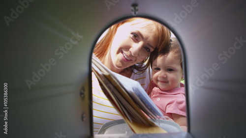 Woman and daughter get mail from mailbox