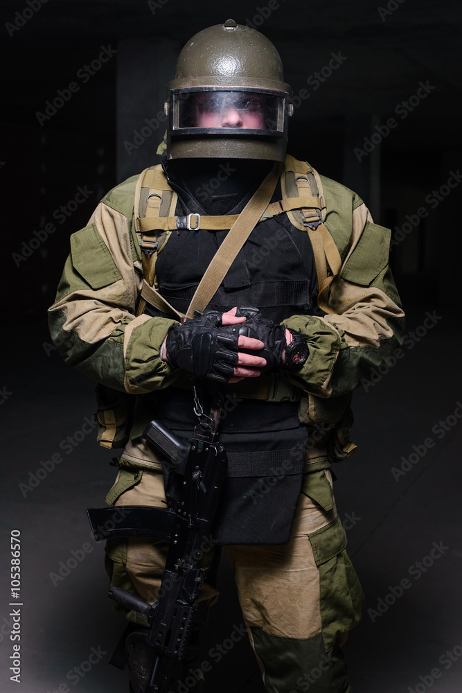Soldiers in heavy helmet and bulletproof vest/Soldier in heavy military helmet and body armor with rifle looking at camera