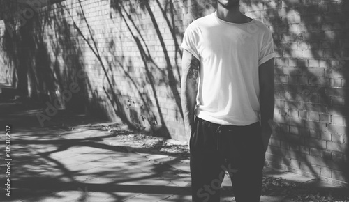 Bearded man with tattoo wearing blank white tshirt. City street background. Horizontal mockup. Black and white. © SFIO CRACHO
