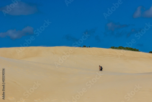 Homem caminhando nas dunas.