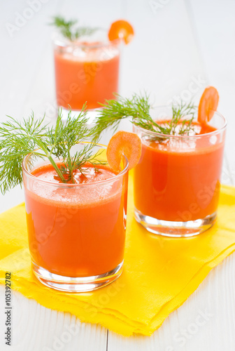 Carrot juice in glasses on yellow napkin