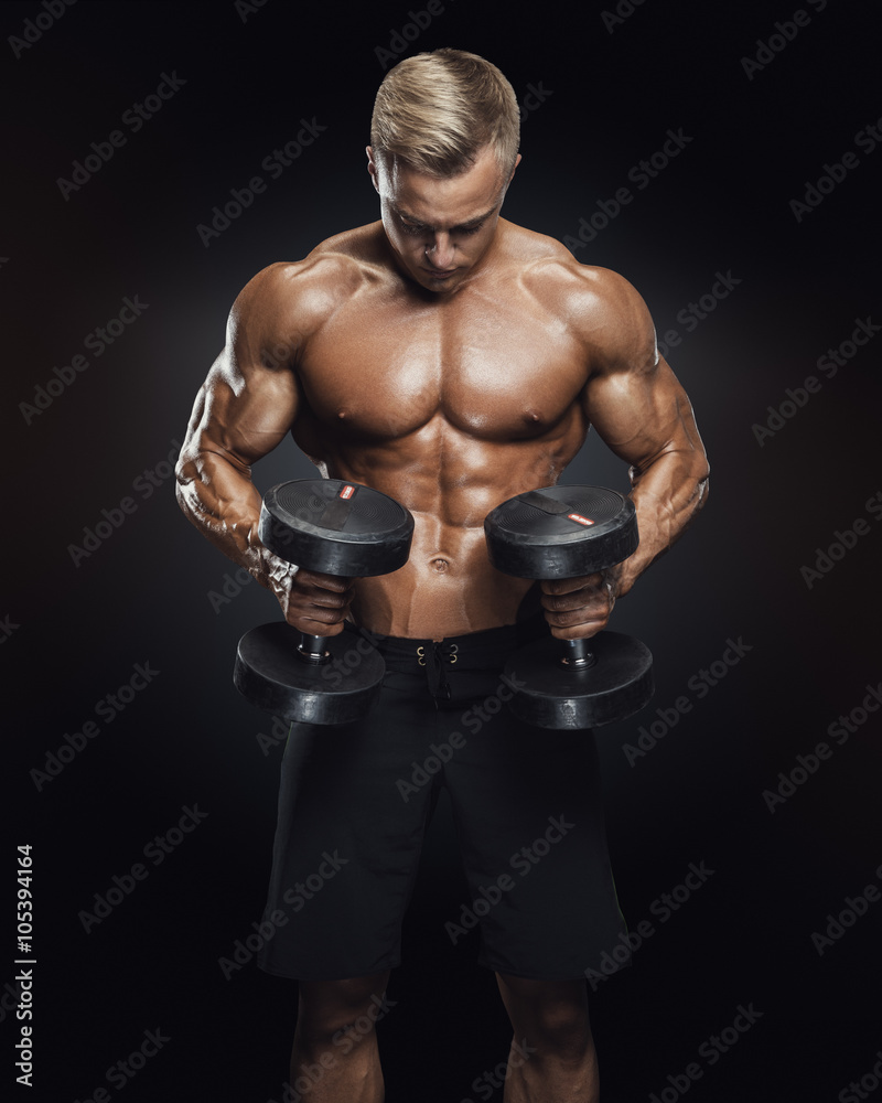 Handsome athletic guy workout with dumbbells