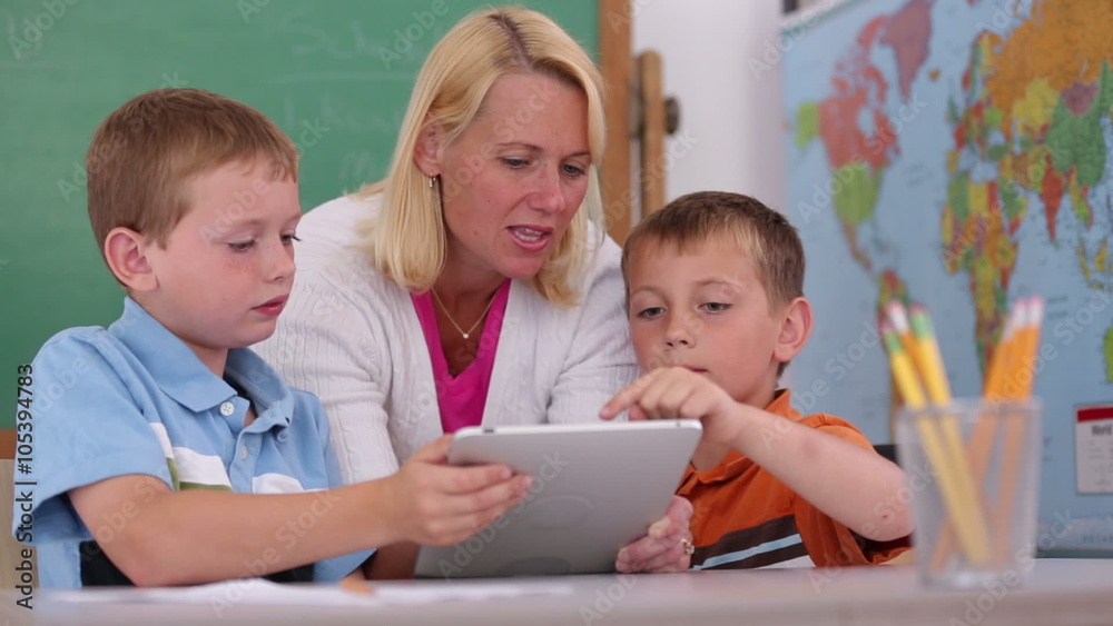 Teacher at school uses digital tablet in classroom Teacher at school uses digital tablet in classroom