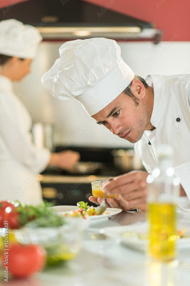 Portrait of a man chef putting sauce on a plateful Portrait of a man chef putting sauce on a plateful