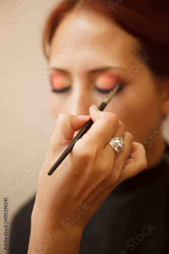 Makeup artist applying make-up on a model.