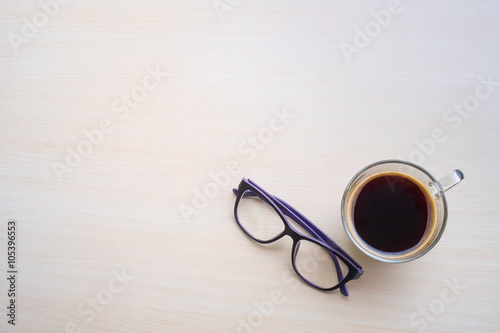Top view of black coffee and glasses on wooden table