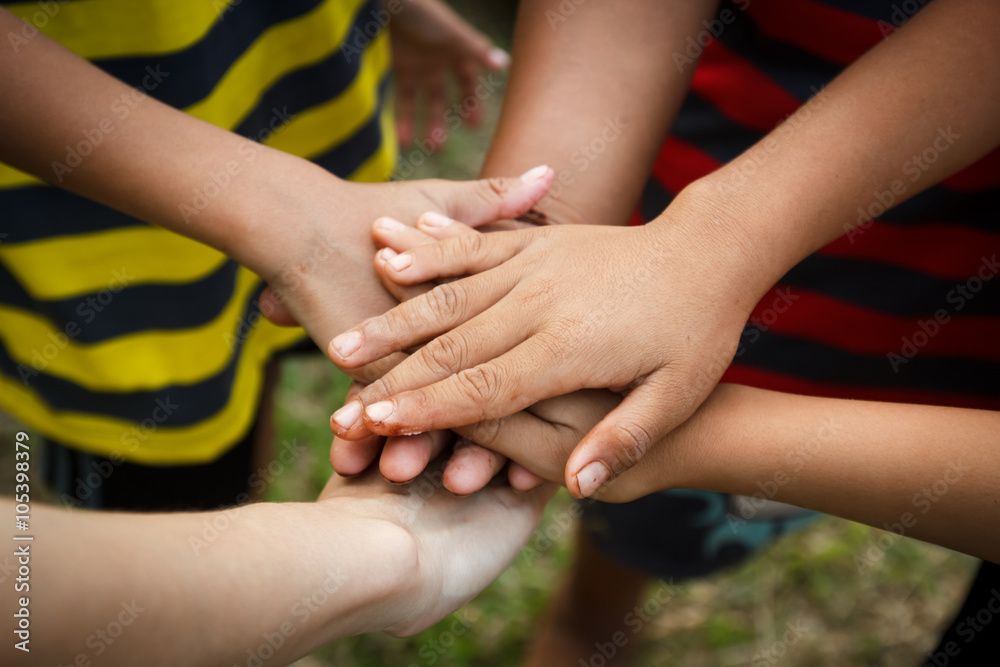 Children putting their hands together in a sign of unity and tea