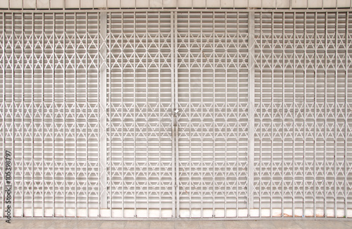 Closed shutters and metal accordion gate of a shoplot including surroundings