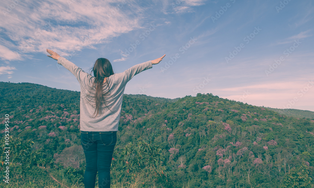 Young woman cheering open arms at mountain