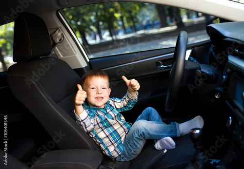 Cute little boy driving fathers car