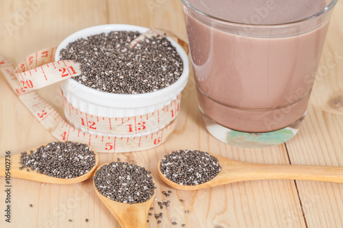 Nutritious chia seeds in bowl and spoon on a wooden