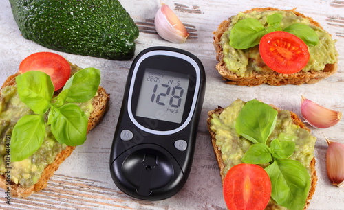Glucose meter and freshly sandwiches with paste of avocado, diabetes, healthy food and nutrition